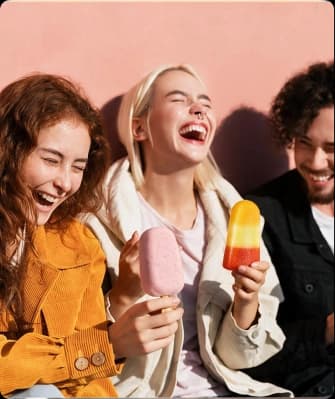 Three friends laughing together over gelato
