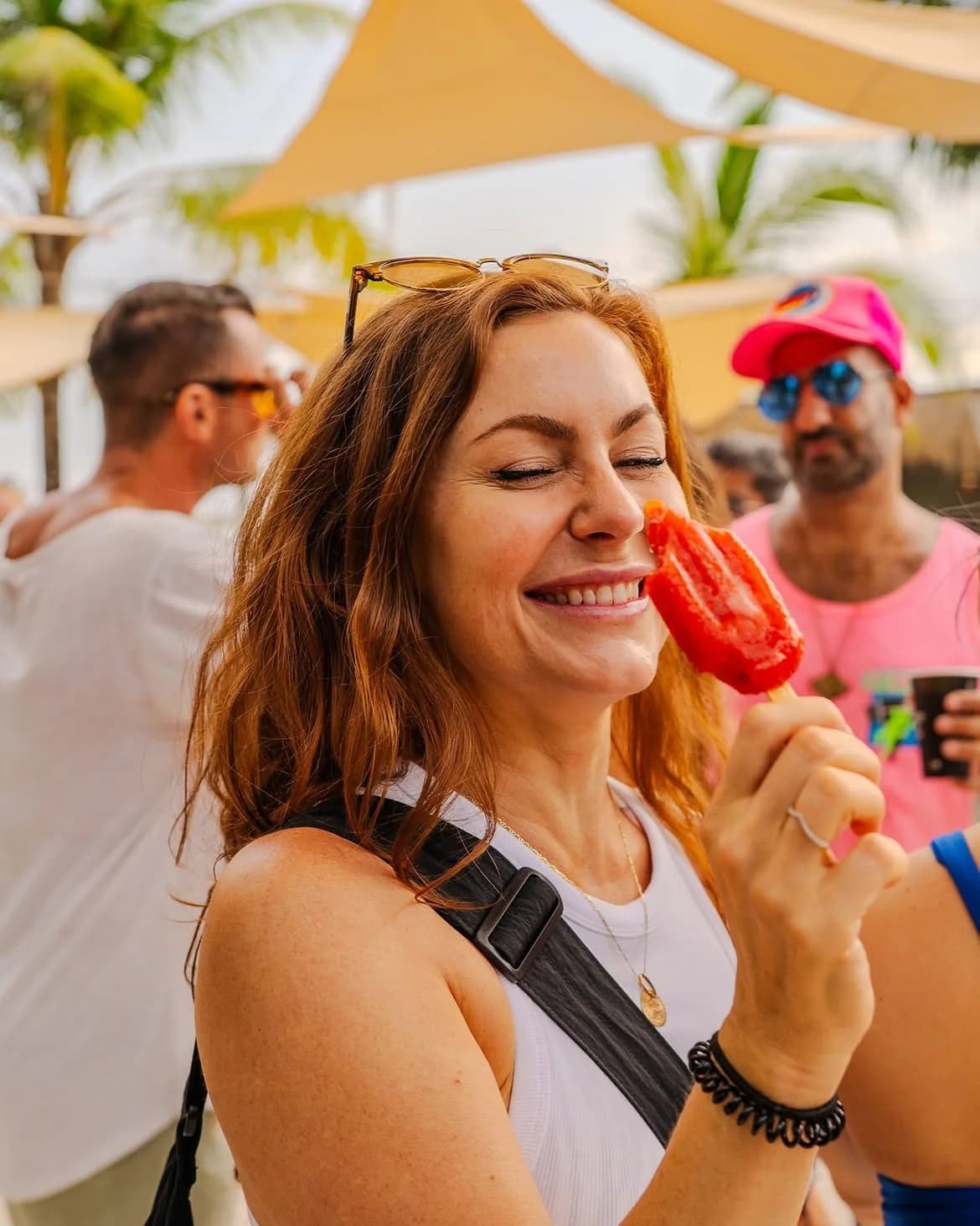 Woman smiling while enjoying a red Leoni popsicle